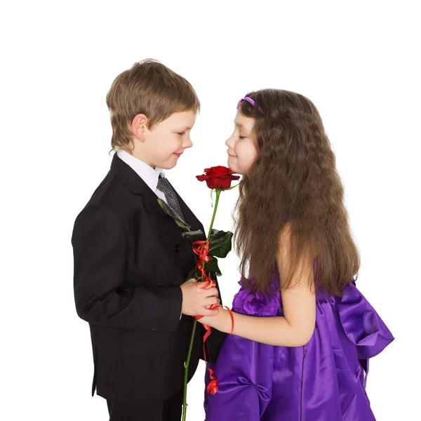 Kleiner Freund schenkt Freundin eine Blume. — Stockfoto