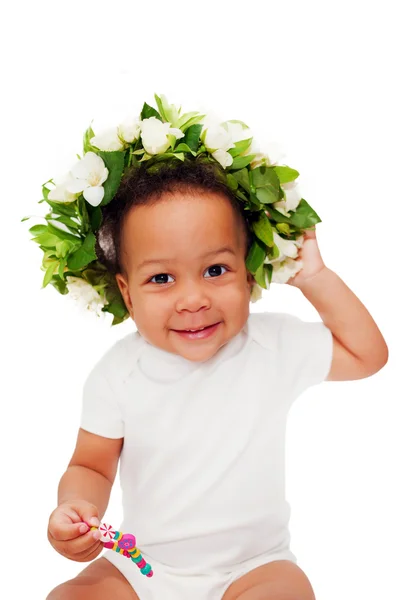 Gelukkig zwarte baby in een bloem krans. — Stockfoto