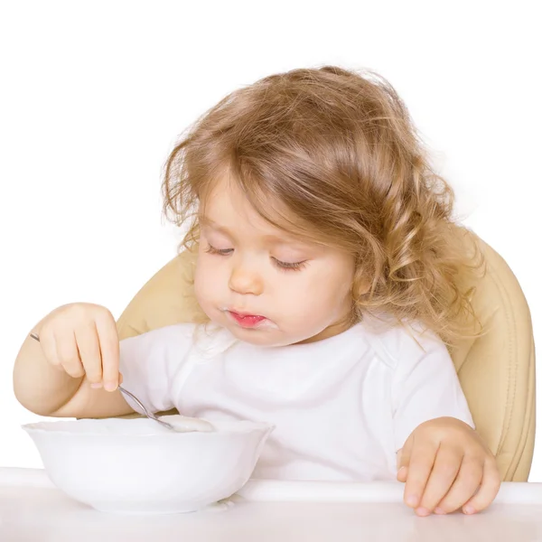 Bebê comendo em uma cadeira alta sozinho . — Fotografia de Stock