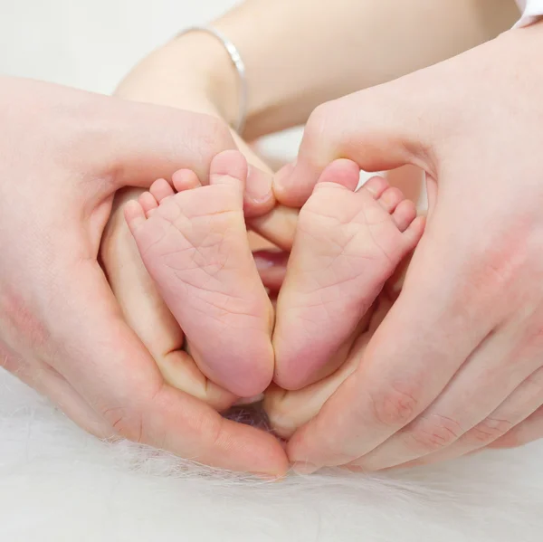 Vater und Mutter halten Füße des Neugeborenen — Stockfoto