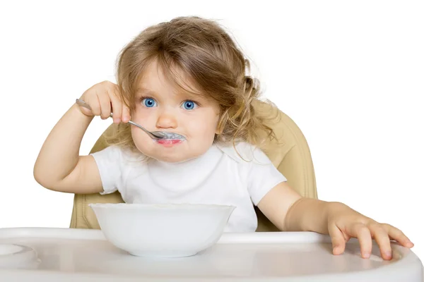 Bebé comiendo comida de bebé en silla alta . — Foto de Stock