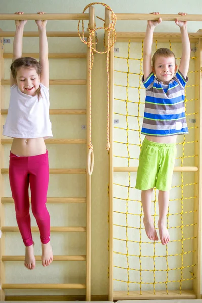 Enfants jouant et accrochant sur la barre horizontale — Photo