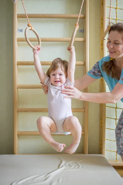 Mãe ajudando seu bebê a praticar esportes — Fotografia de Stock