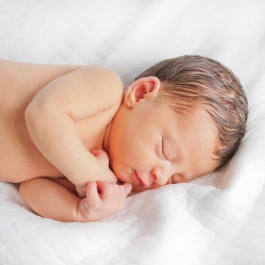 Newborn baby sleeps and smiles  clipart