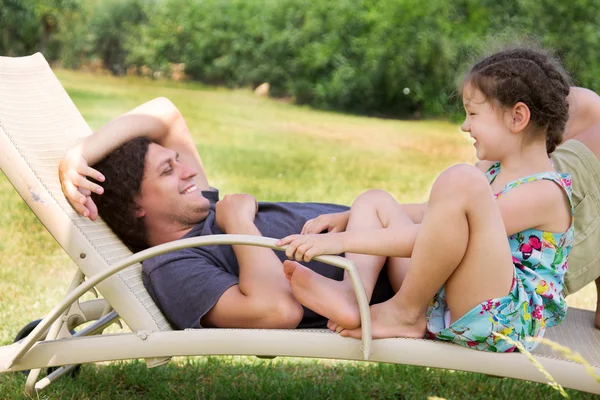 Ojciec i dziecko mówić na leżaku. — Zdjęcie stockowe