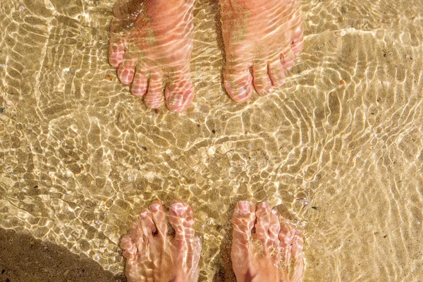 Närbild fötter av man och kvinna i havet — Stockfoto