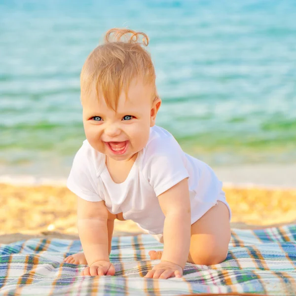 Barnet spelar på stranden nära havet. — Stockfoto