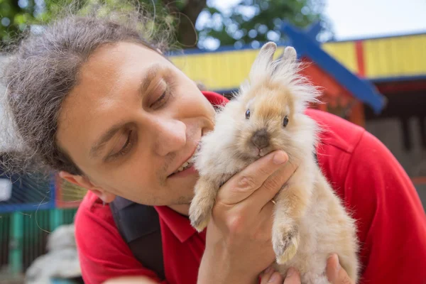 Man de baby konijn kussen. — Stockfoto