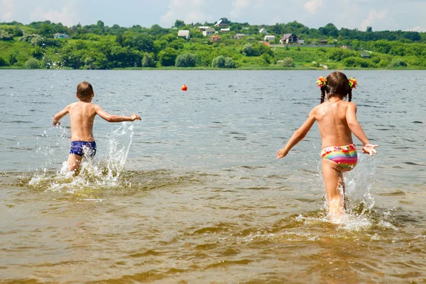 Enfants courant pour nager dans la rivière . — Photo