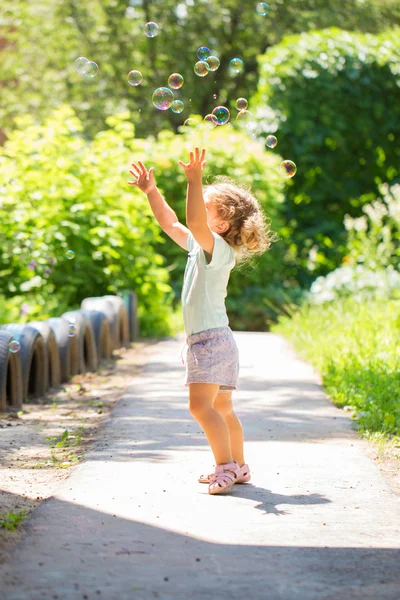 Baby Kind fängt Seifenblasen — Stockfoto