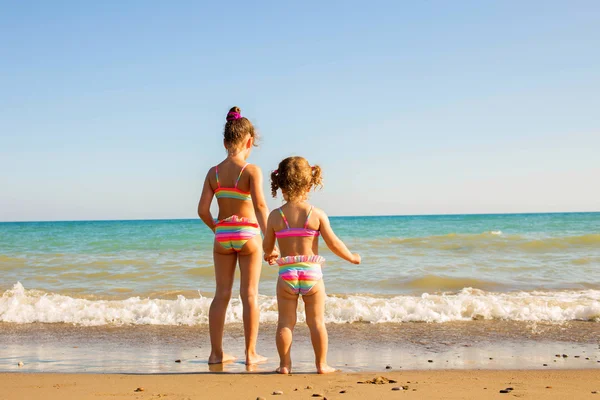 Twee kinderen kijken naar de zee. — Stockfoto