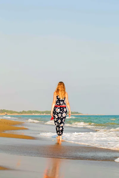 Junge blonde Frau läuft am Strand entlang — Stockfoto