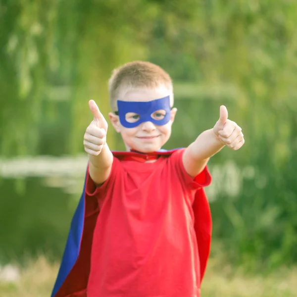 Ragazzo in costume da super eroe che mostra i pollici in su . — Foto Stock