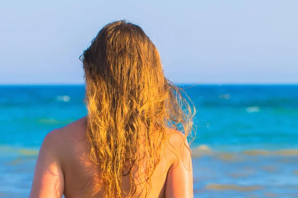Unga blonda kvinnan mot havet bakgrund. — Stockfoto
