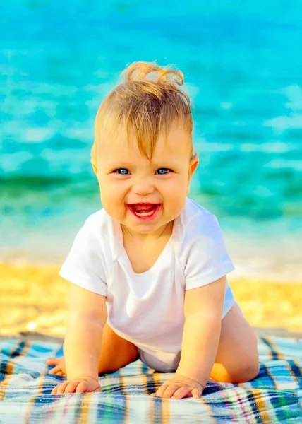 Bain de soleil bébé souriant sur la plage — Photo