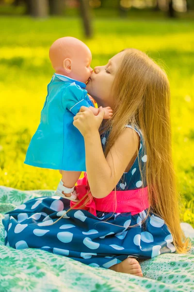 Kleines Mädchen küsst ihre Puppe. — Stockfoto