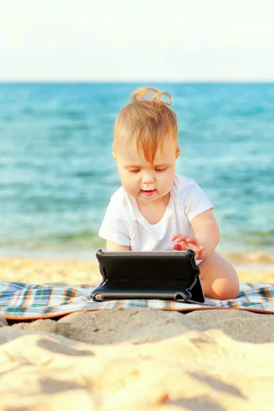 Šťastné dítě s tablet pc na pláži. — Stock fotografie
