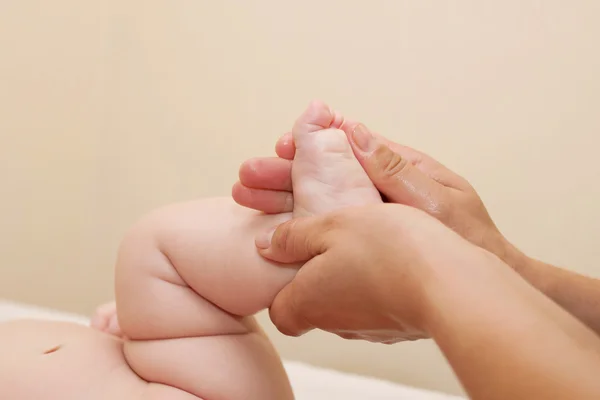 Mère massant les pieds de l'enfant gros plan — Photo