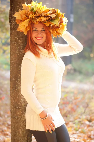 Молодая женщина с короной из опавших листьев клена — стоковое фото
