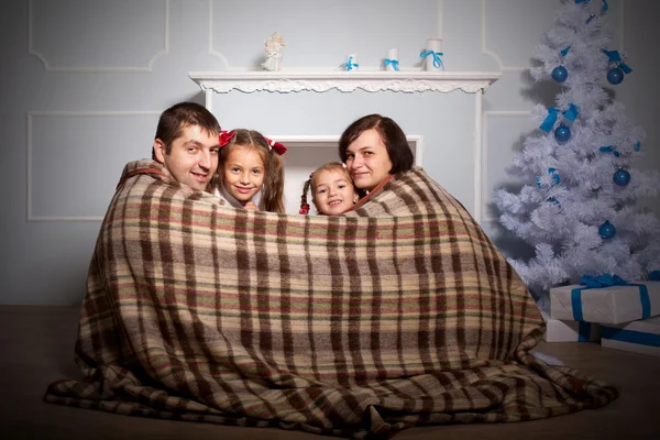 Familia feliz envuelta en cuadros . — Foto de Stock