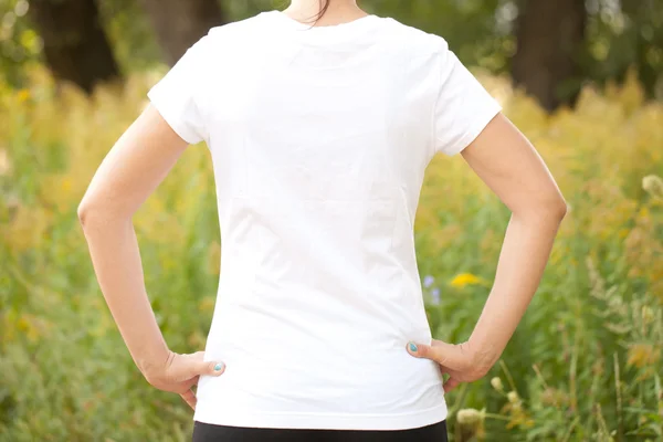 Young woman in white t-shirt outdoors.