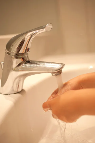 Kid wassen van de handen onder water. — Stockfoto