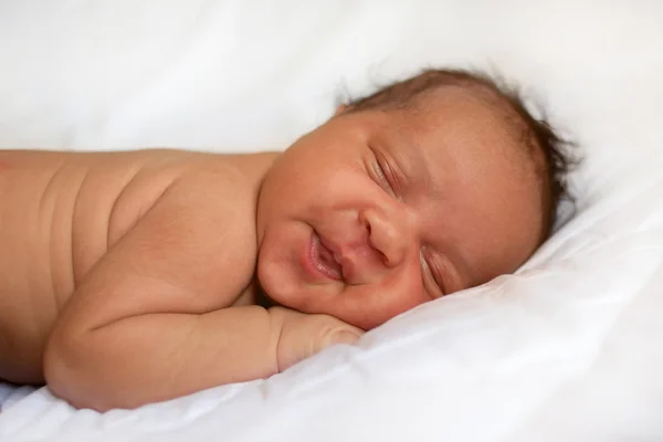Mulatto újszülött baba lány alszik. A fehér ágy fekete baby. — Stock Fotó