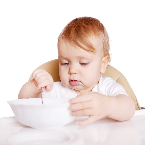 Ребенок ест сам в детском стульчике . — стоковое фото