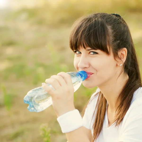 Женщина пьет воду после пробежки — стоковое фото