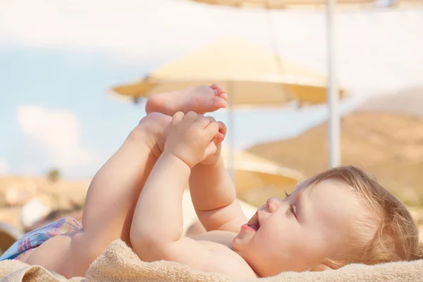 Feliz bebê na praia deitado na espreguiçadeira Imagens De Bancos De Imagens