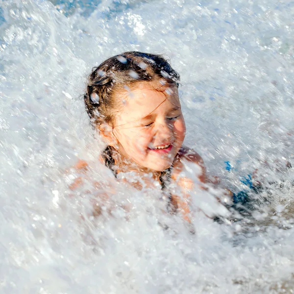 Criança feliz nadando na espuma do mar — Fotografia de Stock