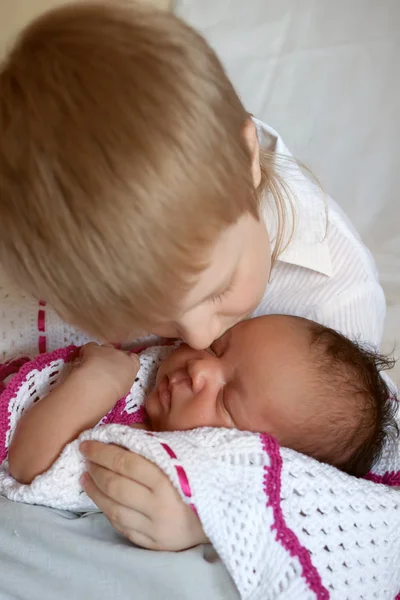 White brother hugging black newborn sister. — Stock Photo, Image