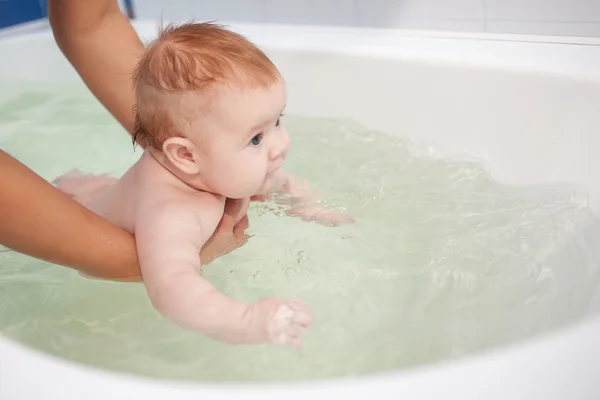 Little baby swimming in the bath. Stock Photo