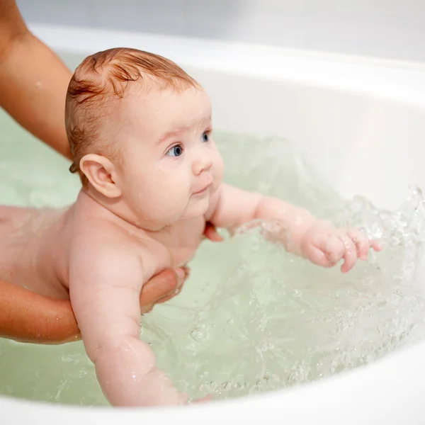 3 month baby swimming in the bath Stock Photo