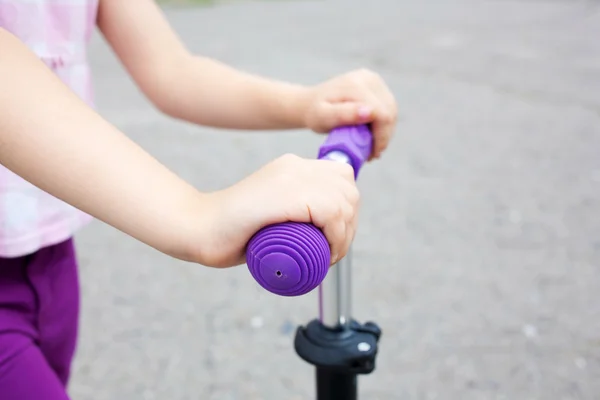 Las manos de los niños sosteniendo scooter manillar — Foto de Stock