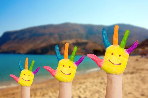 Sonriente en las manos de la familia contra la playa y el mar azul —  Fotos de Stock