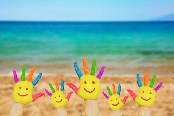 Sonriente en las manos contra el fondo de playa . —  Fotos de Stock