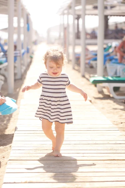 Baby walking along wooden walkway — Stockfoto