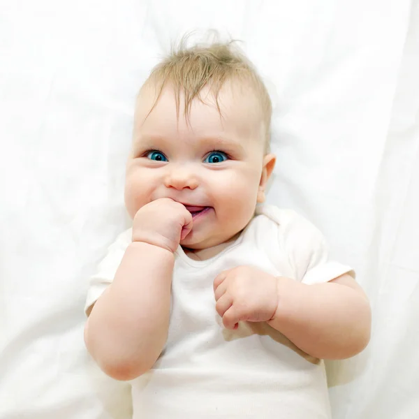 Sorrindo bebê chupando seu dedo — Fotografia de Stock