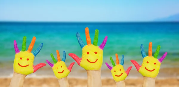 Niños sonrientes manos en una playa —  Fotos de Stock