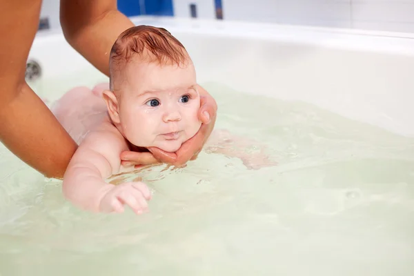 お風呂で泳ぐ幸せの生まれたばかりの赤ちゃん. — ストック写真