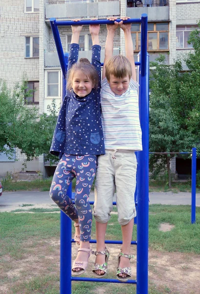 Мальчик и девочка висят на стойке . — стоковое фото