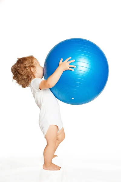 Bébé jouant avec une grosse balle de fitness . — Photo