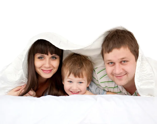 Família engraçada na cama coberta com um cobertor . — Fotografia de Stock