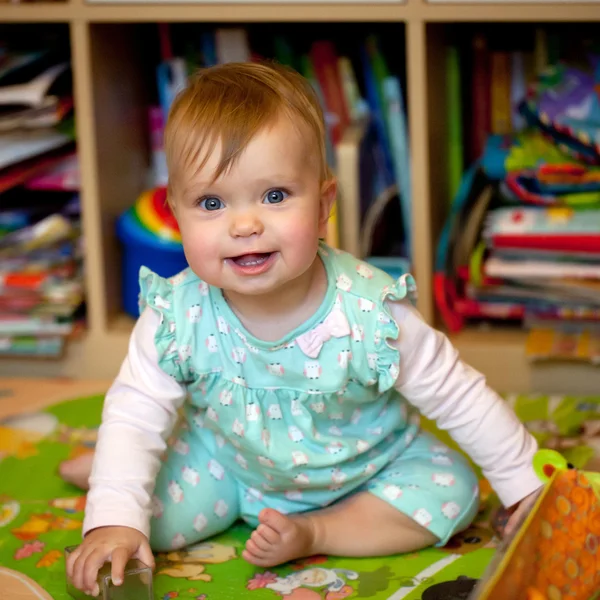 Lächelndes Baby auf dem Boden im Kinderzimmer — Stockfoto