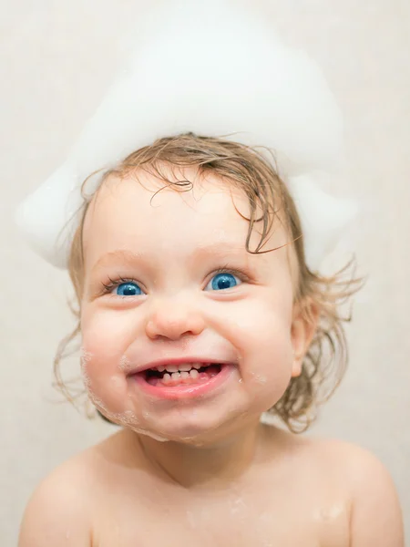 Bebê sorridente está lavando o cabelo — Fotografia de Stock