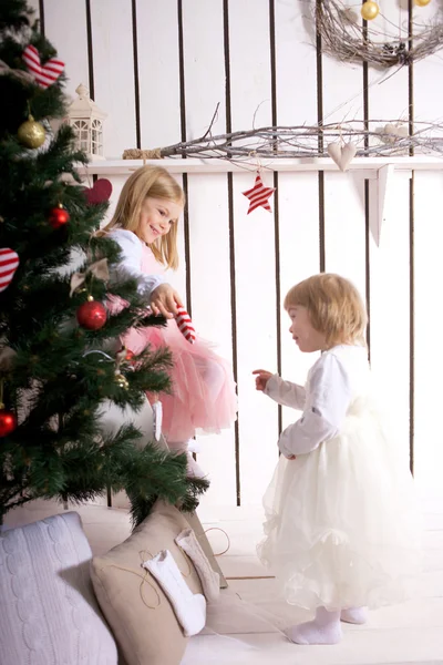 Dos hermanas pequeñas decorando el árbol de Navidad . — Foto de Stock