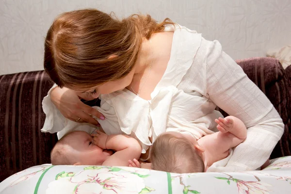 Bebés gemelos lactantes con dispositivo de alimentación — Foto de Stock