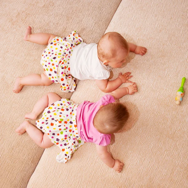 Twee baby tweeling kruipende togethe — Stockfoto