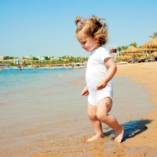 Niedliches kleines Mädchen hat Spaß am Strand. — Stockfoto